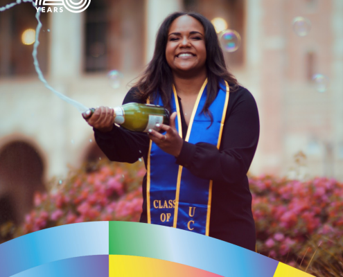 Cynamon Mantley ’18 smiles in front of UCLA’s Royce Hall while holding a bottle spraying celebratory bubbles. She wears a blue-and-gold graduation stole. Text identifies her fields of study as African American Studies and Italian and includes the CCCP 25 Years and UCLA logos.
