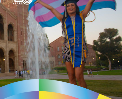 Ajana Orozco ’21 stands in front of UCLA’s Royce Hall and fountain wearing graduation regalia, holding a transgender pride flag overhead. Text identifies her field of study as Gender Studies and includes CCCP’s 25 Years and UCLA logos.
