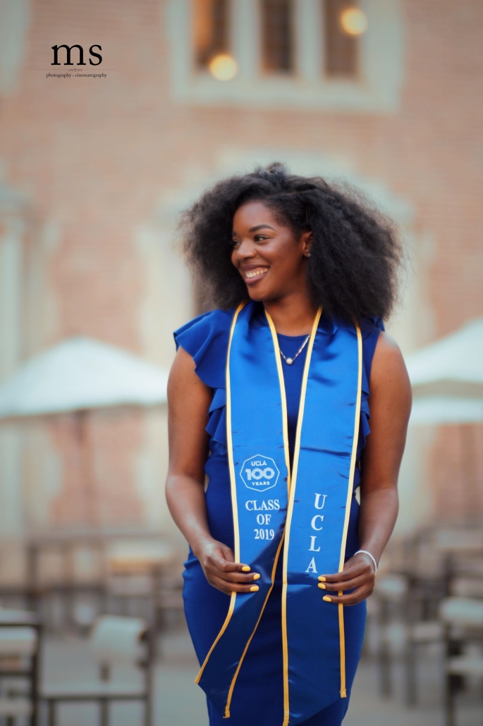 Aurelia smiles in a blue dress and UCLA Class of 2019 graduation sash during a graduation portrait session.