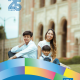 Yazmin Gonzalez, UCLA Latin American Studies class of 2016 and M.A. class of 2017, sits outdoors with two children near a campus building.