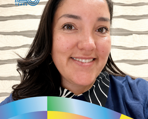 Portrait of Leticia Abril Diaz, UCLA Sociology and Gender Studies class of 2012, smiling against a textured wall.
