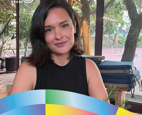 Liliana Islas, UCLA Women Studies class of 2009, M.A. class of 2010, and Ph.D. class of 2018, sits indoors near large windows overlooking trees.