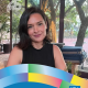 Liliana Islas, UCLA Women Studies class of 2009, M.A. class of 2010, and Ph.D. class of 2018, sits indoors near large windows overlooking trees.