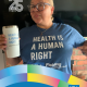 Magali Sanchez-Hall, UCLA Chicana/o Studies and Public Policy alumna, holds a mug while wearing a shirt that reads, “Health is a human right,” in a CCCP 25th anniversary–branded alumni graphic.